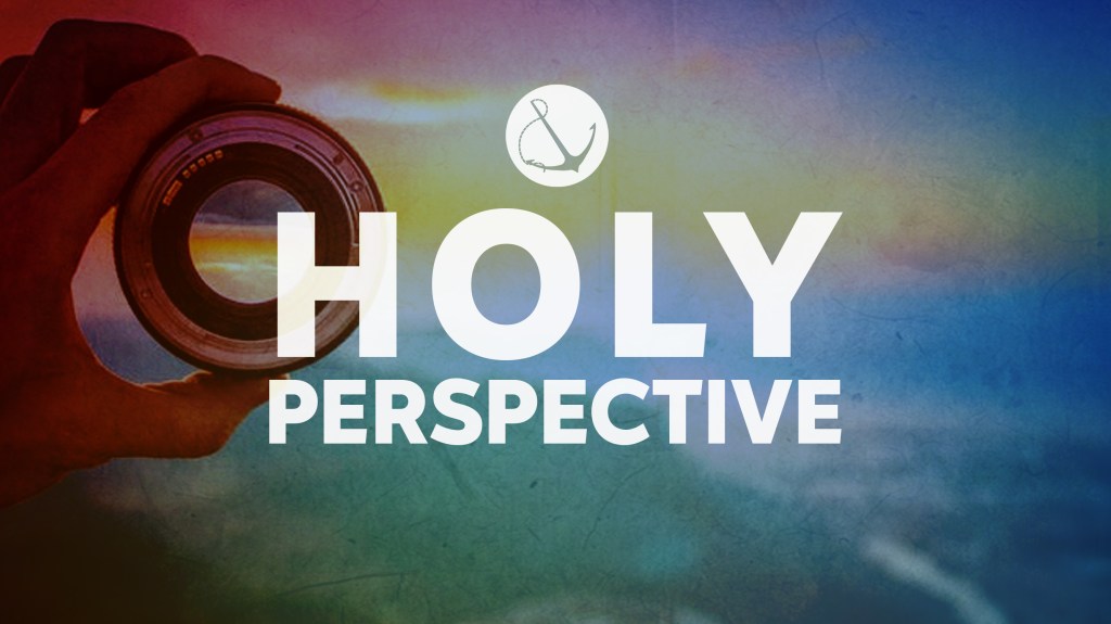 Image of a hand holding a camera lens with text overlaid, "Holy Perspective"