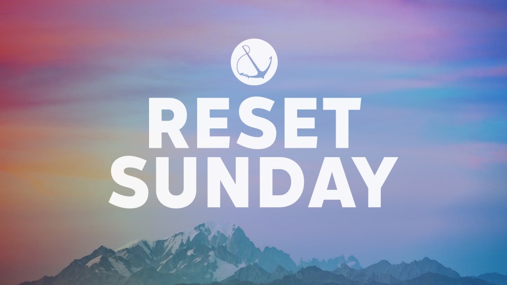 Image of a mountain peak with a sunrise sky, with text overlaid, "Reset Sunday"